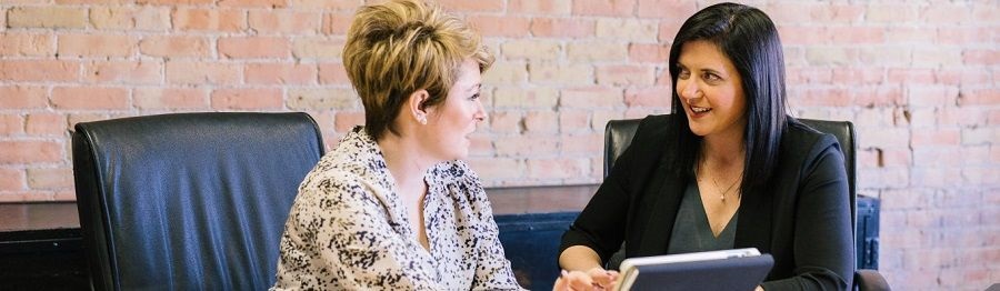 two people talking at a desk